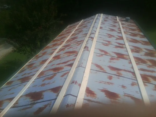Rusted metal roof panels with new wood purlins before replacement — Storm Damage Roof Repair in Greeley by Roofing Brothers